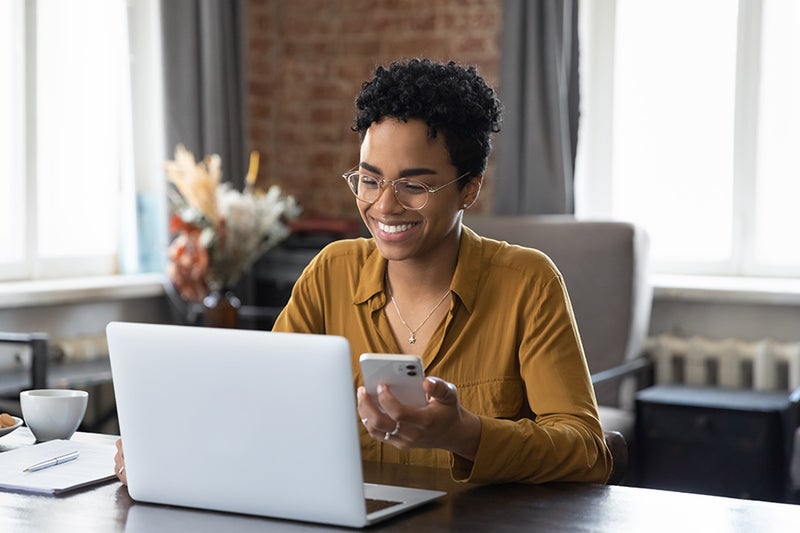 Woman smiling while on the computer - Hardin Buick GMC in Anaheim CA